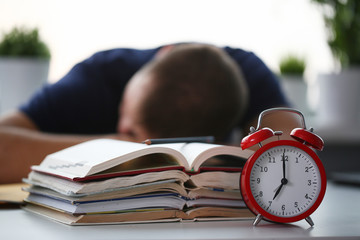Tired male student at workplace in room