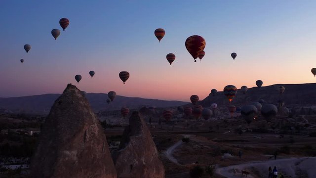 Aerial dolly in shot as hot air balloons launch over Goreme Cappadocia at sunrise.