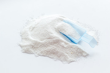 Household chemicals. Washing powder in plastic spoon on white background