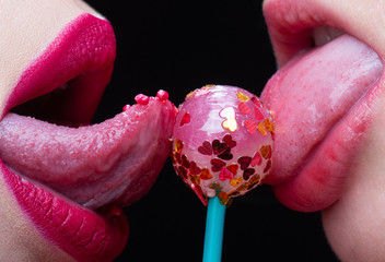 Sweet kiss lips. Lesbian love concept. Lollipop between female lips. Erotic dessert. Passion between two women.