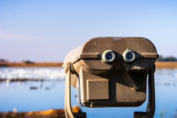 Outdoor daytime viewing telescope looking over the wetlands of Merced National Wildlife Refuge,...