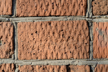 Old red brick wall lit by the sun closeup. Abstract background