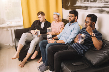 Group of friends watching television at home together