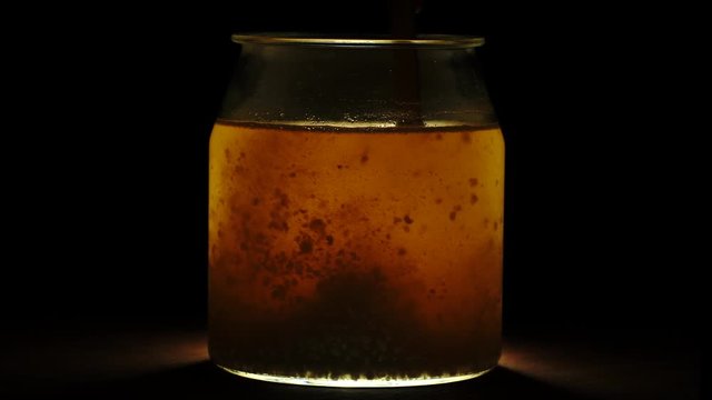 mixing water based kefir with wooden spoon helping fermenation proces. close up shot