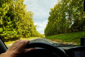 Track from the car window and white clouds on blue sky. Natural landscape