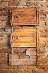 Three old broken terracotta roof tiles hang on a brick wall. Decor