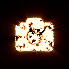 Symbol photo camera burned on a black background. Bright shine