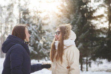 Two young, pretty women in a snowy forest.