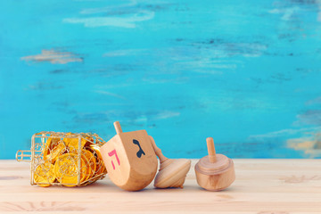 religion concept of of jewish holiday Hanukkah with wooden dreidels (spinning top) and chocolate coins over table and blue background