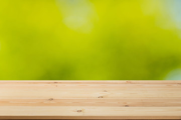 Wooden board  table in front of a blurred background. Perspective brown wood with a blurry background of nature or park - can be used to showcase or assemble your products. Mock up to  the product.