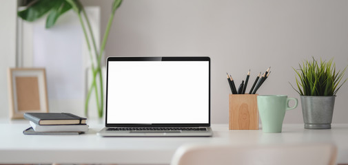 Close-up view of comfortable workplace with open blank screen laptop computer