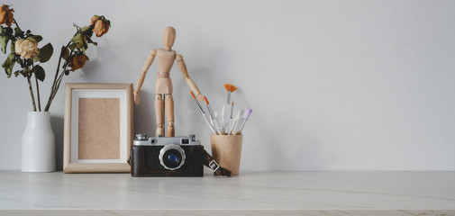 Minimal artist workplace with office supplies and camera on marble table