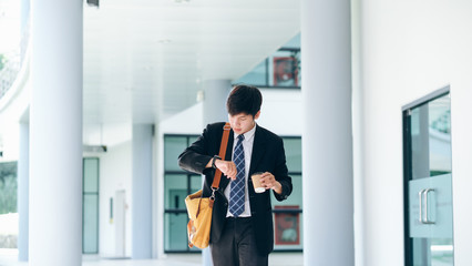 Young businessman worried looking at his wrist watch.