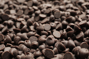 Delicious chocolate chips as background, closeup view