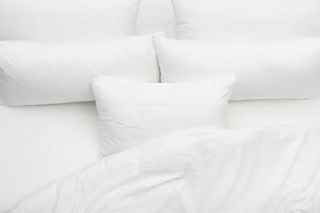 Fototapeta na wymiar Soft white pillows and blanket on bed, top view