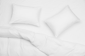 Fototapeta na wymiar Soft white pillows and blanket on bed, top view