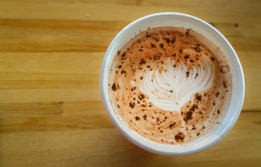 A warm cup of cocoa from above, on a wooden table background. Cozy café. Hot drink.