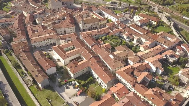 Top down aerial view of a small historic town Venzone in Northern Italy with red tiled roofs of old buildings.
