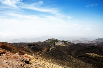 Fototapeta na wymiar Panoramic wide view of the active volcano Etna on island Sicily, Italy extinct craters on the slope, traces of volcanic activity. Barren landscape of lava stones