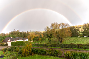A traditional French house is framed by a rainbow over countryside in Bernay, Normandy,France,October, 25, 2019