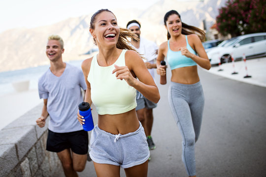 Happy Fit People Running And Jogging Together In Summer Sunny Nature