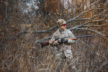 Hunter handsome guy with weapon. Hunter spend leisure hunting. Hunting equipment. Brutal masculine hobby. Man observing nature background. Hunter hold rifle. Safety measures. Natural environment.