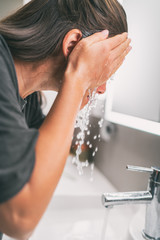 Face wash woman splashing water washing face rinsing soap from skin in sink under running cold...
