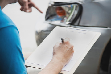 Insurance agent working during on site car accident claim process - people and car insurance claim...