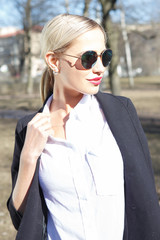 Young fashion beautiful woman in sunglasses on a city street