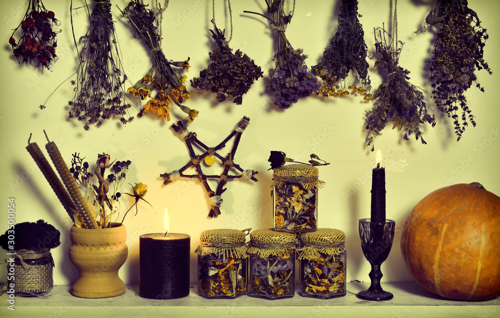 Wall mural Witch still life with pentagram, dry flowers, pumpkin, black candle and jars with potion.