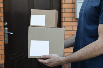 Delivery man hold blank boxes outdoor, space for text
