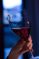 A glass of red wine in woman hand