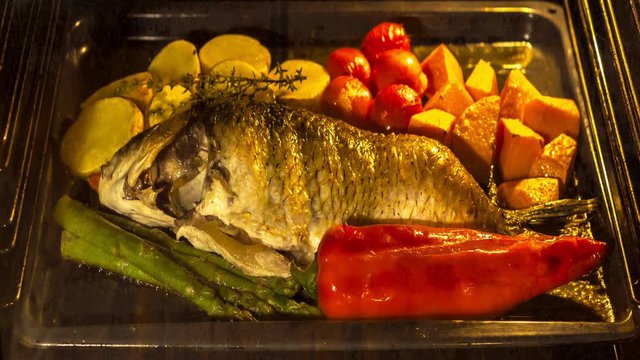 Cooking fish and vegetables in baking oven, time lapse
