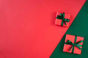 Red gift boxes on green and red background. Christmas card. Flat lay. Top view with space for text	