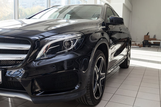Black Mercedes Benz Gla class 2016 year front side view with dark gray interior in excellent condition in a dealership with white walls