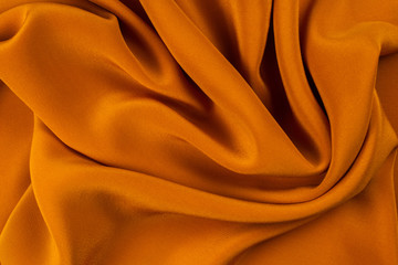 Golden silk or satin luxury fabric texture can use as abstract background.