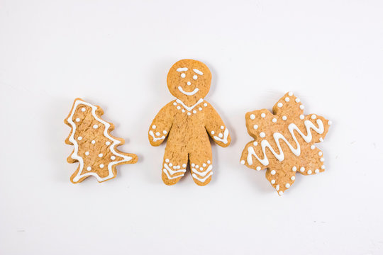 Gingerbread gingerbread in the form of a man, a house, a Christmas tree on a light background.