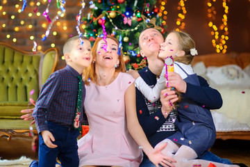 happy family celebrates in a decorated room near the festive Christmas tree. Waiting for the holiday