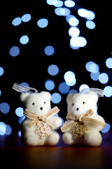 Christmas decoration with little white bears on blurred background of lights.