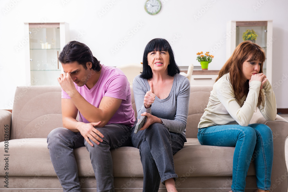 Wall mural young family and mother-in-law in family issues concept