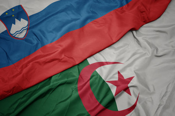 waving colorful flag of algeria and national flag of slovenia.