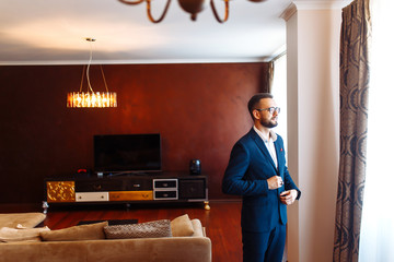 Elegant groom in suit. Businessman. Portrait of the luxury groom in a jacket. The morning of the...