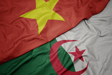 waving colorful flag of algeria and national flag of vietnam.