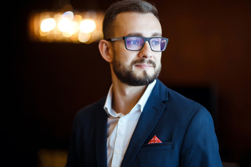 Elegant groom in suit. Businessman. Portrait of the luxury groom in a jacket. The morning of the groom, bridegroom's fees. Sexy man in suit posing. Wedding day.