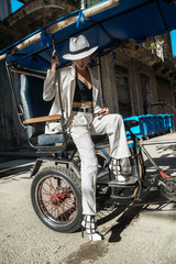 Fototapeta na wymiar Stylish woman in typical public transportation taxi bike in cuba