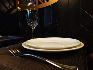 Plate, fork, knife and glass on the table in the restaurant