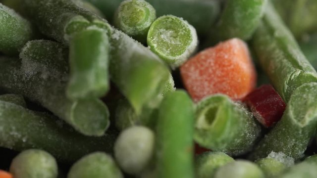 Frozen Mixed Vegetables. Broccoli, green beans, peas, carrots. Macro, rotating background. Freezer food