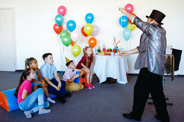 Magician, an illusionist shows tricks.