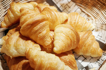 Many delicious mini croissants in the wicker basket.
