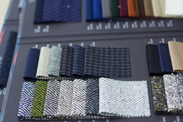 Fabric samples in the tailor shop and tailored suits. Concept of: tailoring, businessman, elegance.